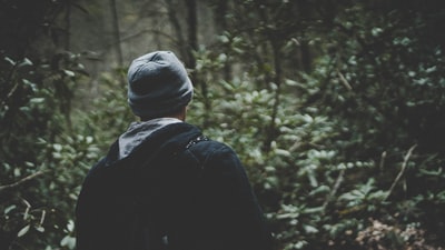 人在森林的黑色连帽衫,穿着灰色无檐小便帽
